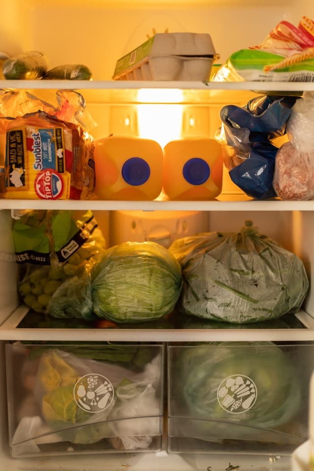 A community fridge being stocked with fresh local produce