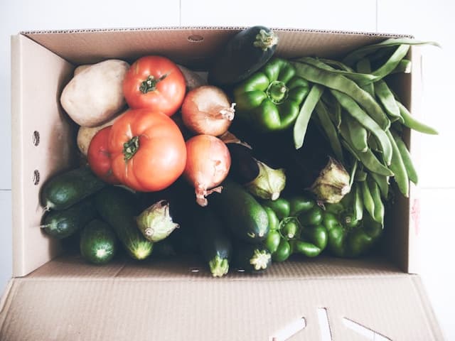 A neighbour collecting a free box of vegetables from a community hub